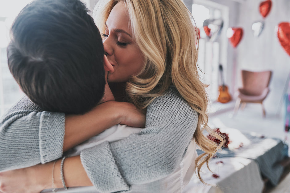 A couple in love, blond woman kissing a man on cheek. Fizzy romance.